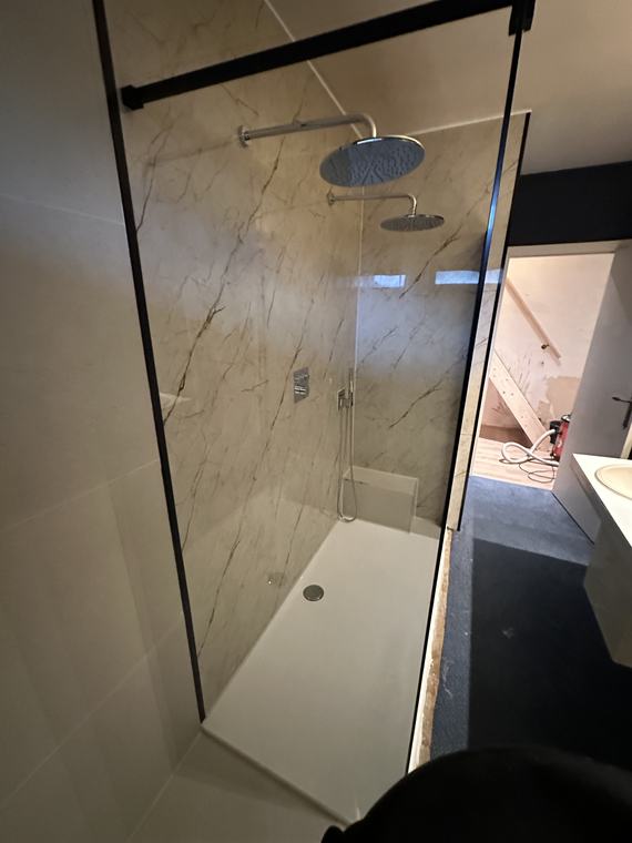 Inloopdouche met glazen wand en zwarte accenten in een zolderbadkamer