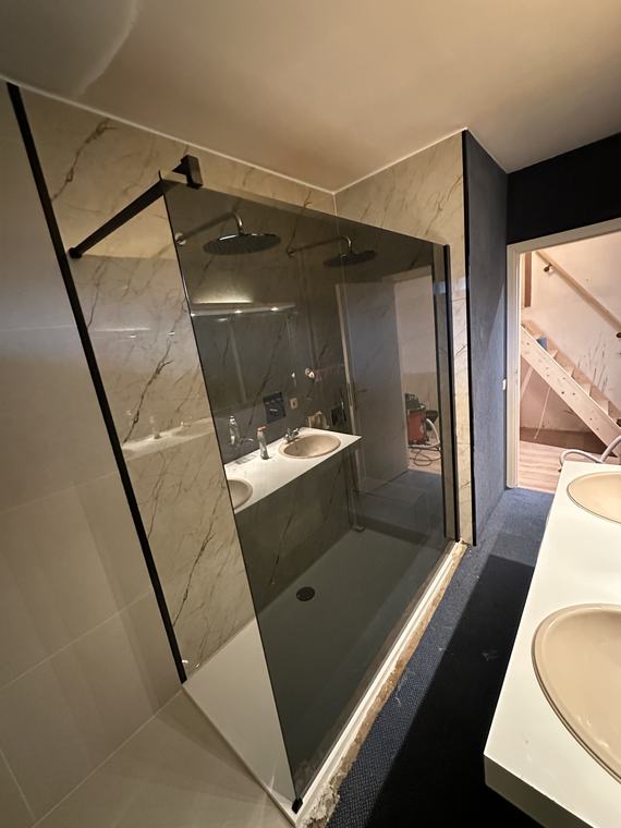 Afgewerktebadkamer met inloopdouche, dubbele lavabo en marmerlooktegels