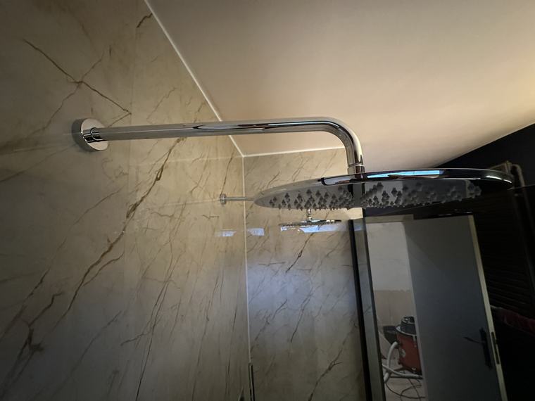 Regendouche tegen een wand in marmerlook