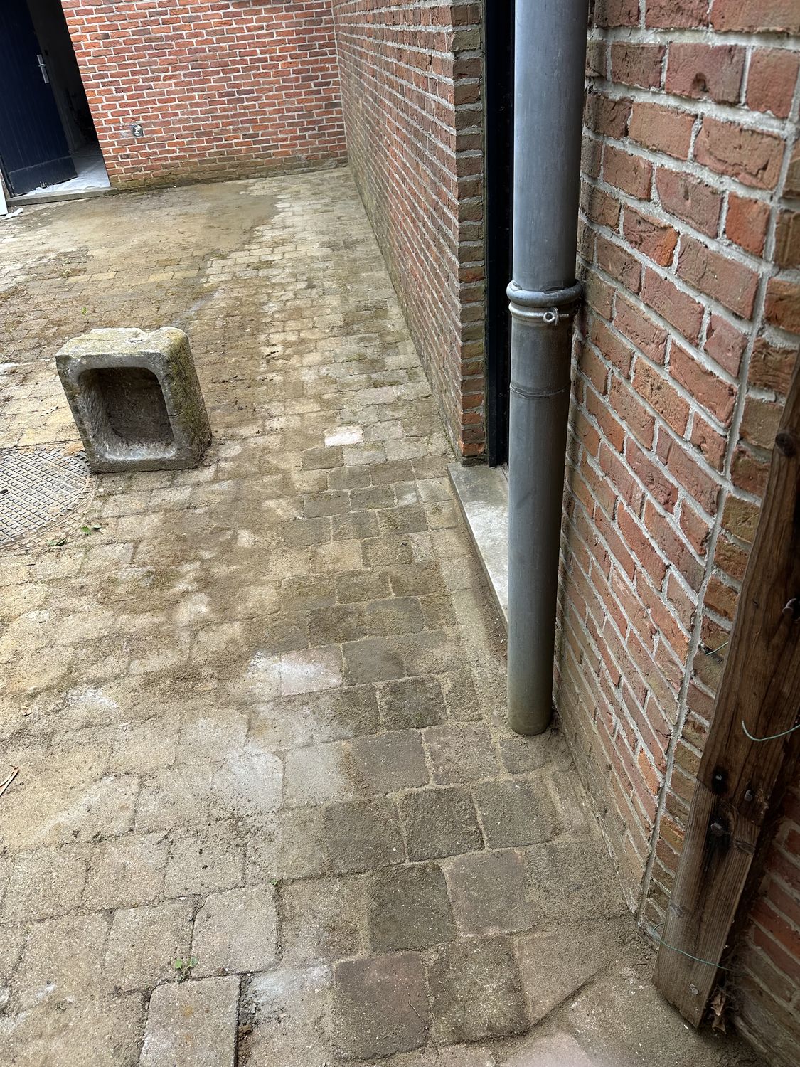 Heraangelegde koer met kasseien en een nieuwe regenwaterafvoer