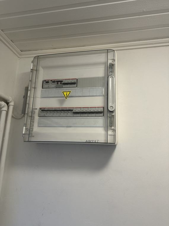 Nieuwe verdeelkast tegen de wand met opbouwleidingen